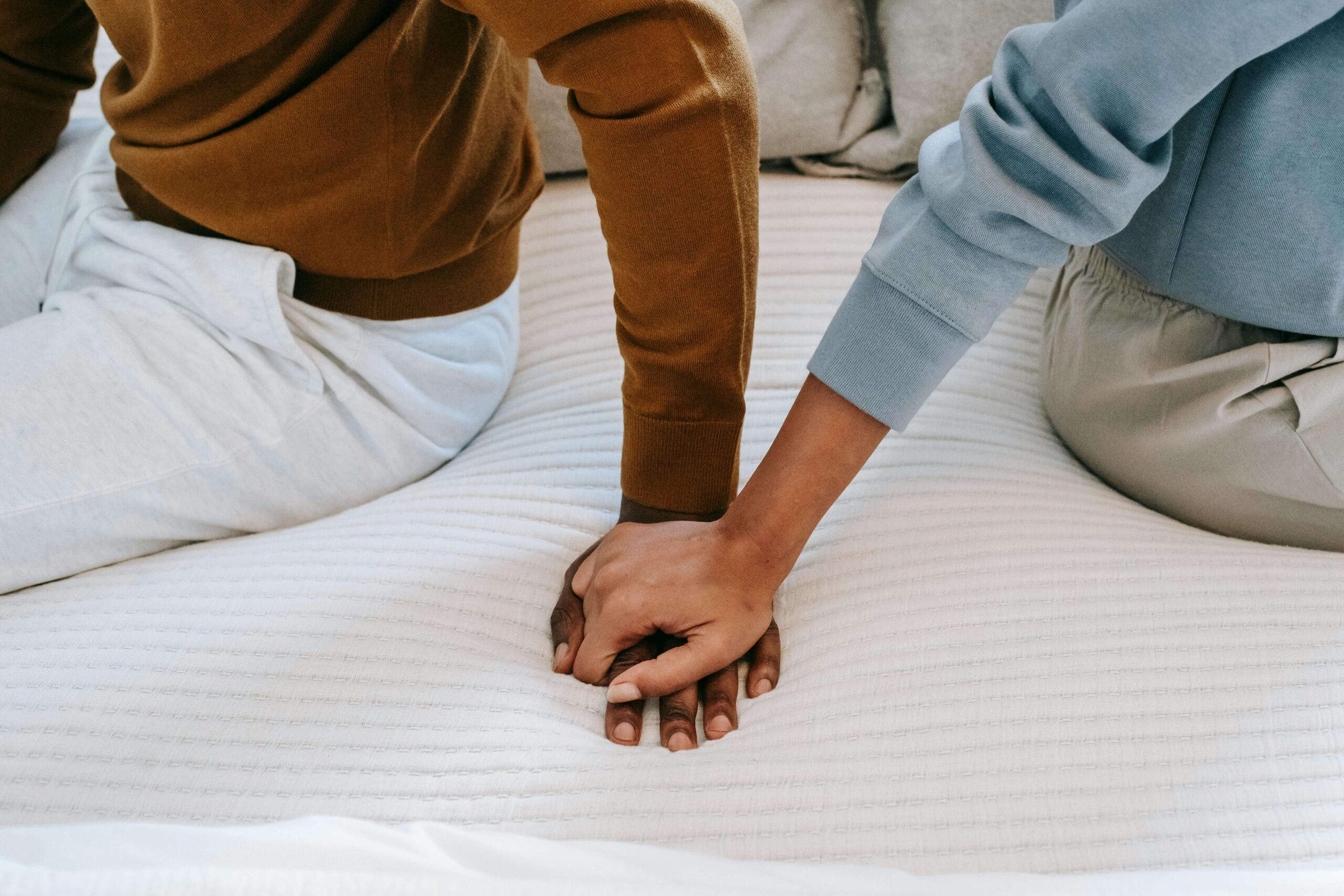Close-up of a couple holding hands, symbolizing emotional connection fostered through individual relationship counseling vs. couples counseling in Denver, CO.