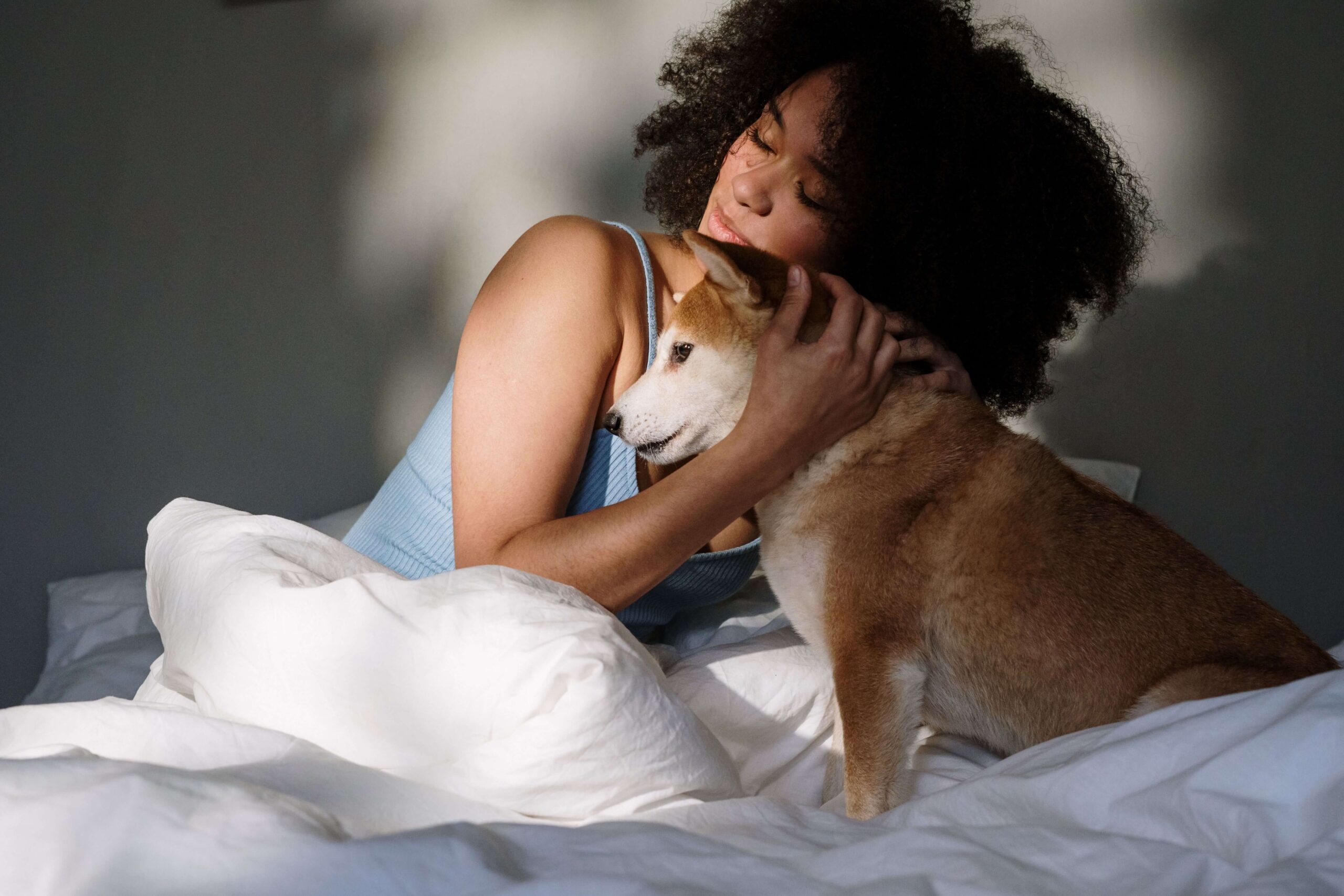 Finding Emotional Comfort - validation in relationships denver co - individual relationship counseling denver co - therapy for validation in relationships denver co - colorado Woman sitting in bed while hugging her dog, representing self-soothing, emotional support, and personal comfort while exploring validation in relationships in Denver, CO.