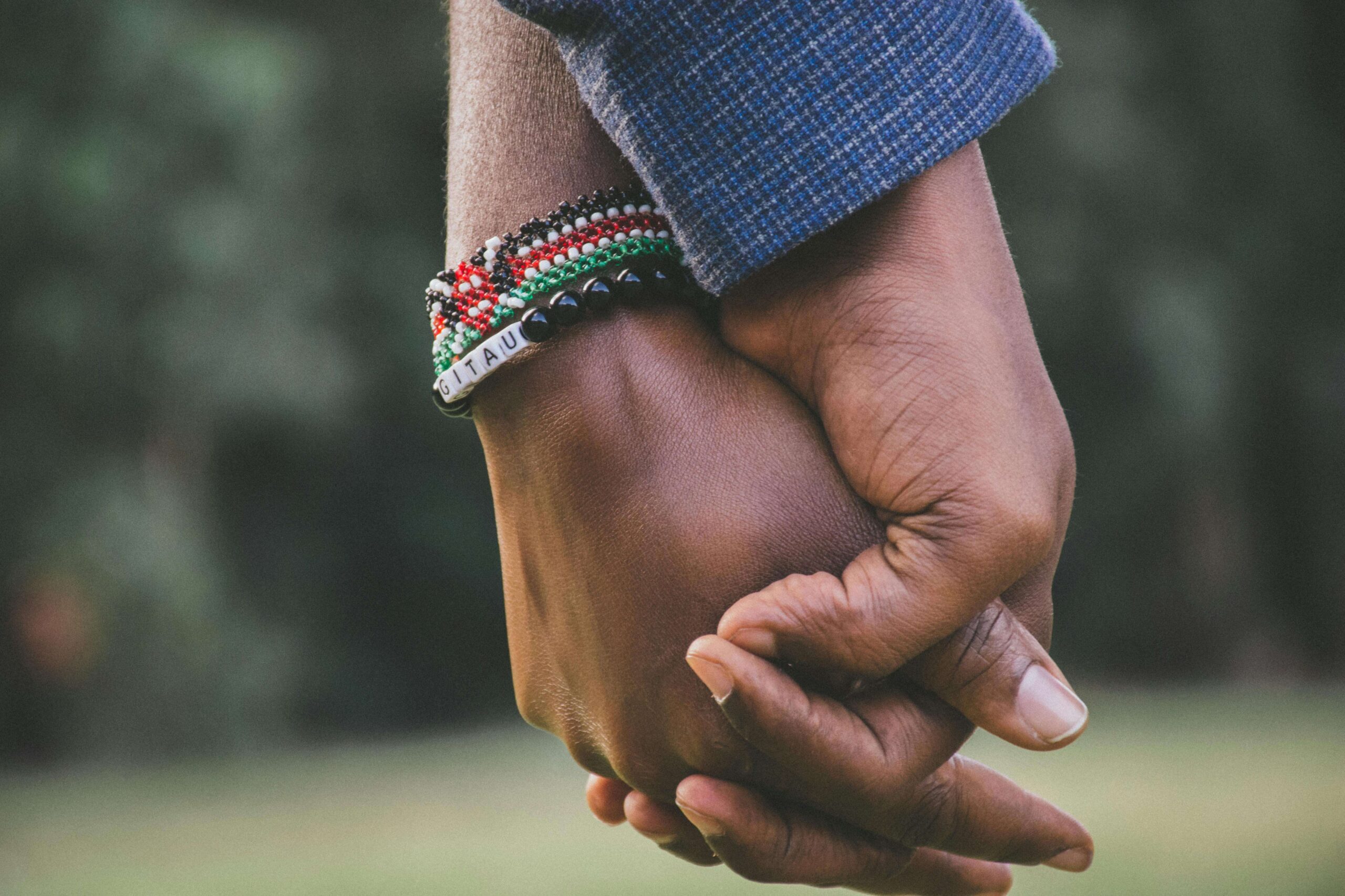 Close-up of two people holding hands, symbolizing safety, connection, and healing supported through therapy for relationship trauma in Denver, CO.