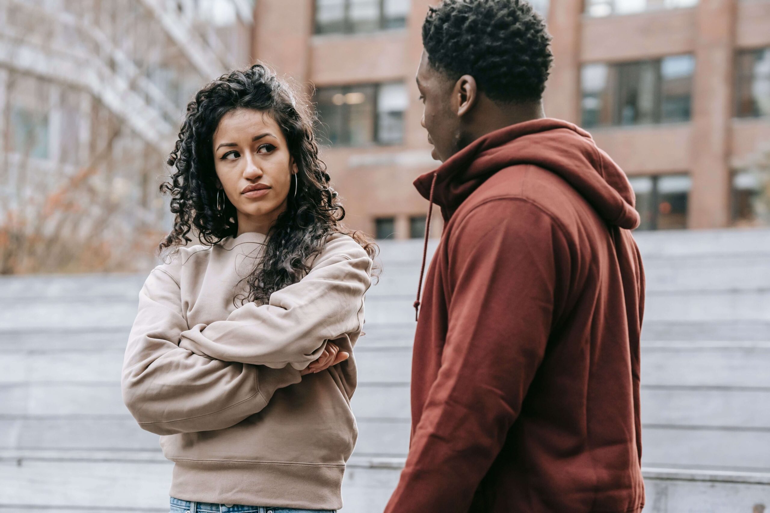 Couple standing outdoors with the woman looking uncertainly at the man, representing emotional insecurity explored in individual relationship counseling for emotional security in Denver, CO.