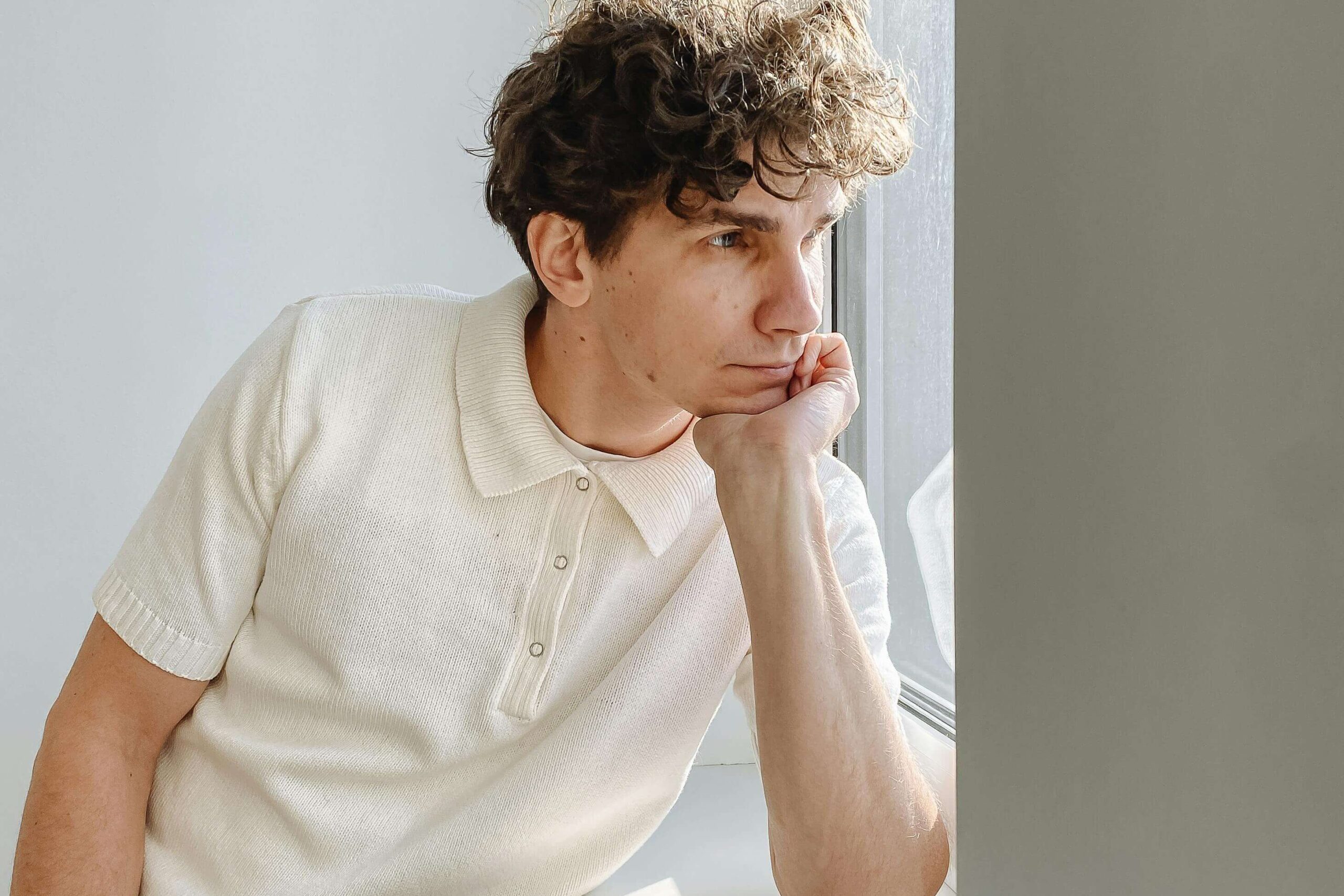 Man looking thoughtful, illustrating reflection and insight supported by self-esteem counseling in Denver, CO.