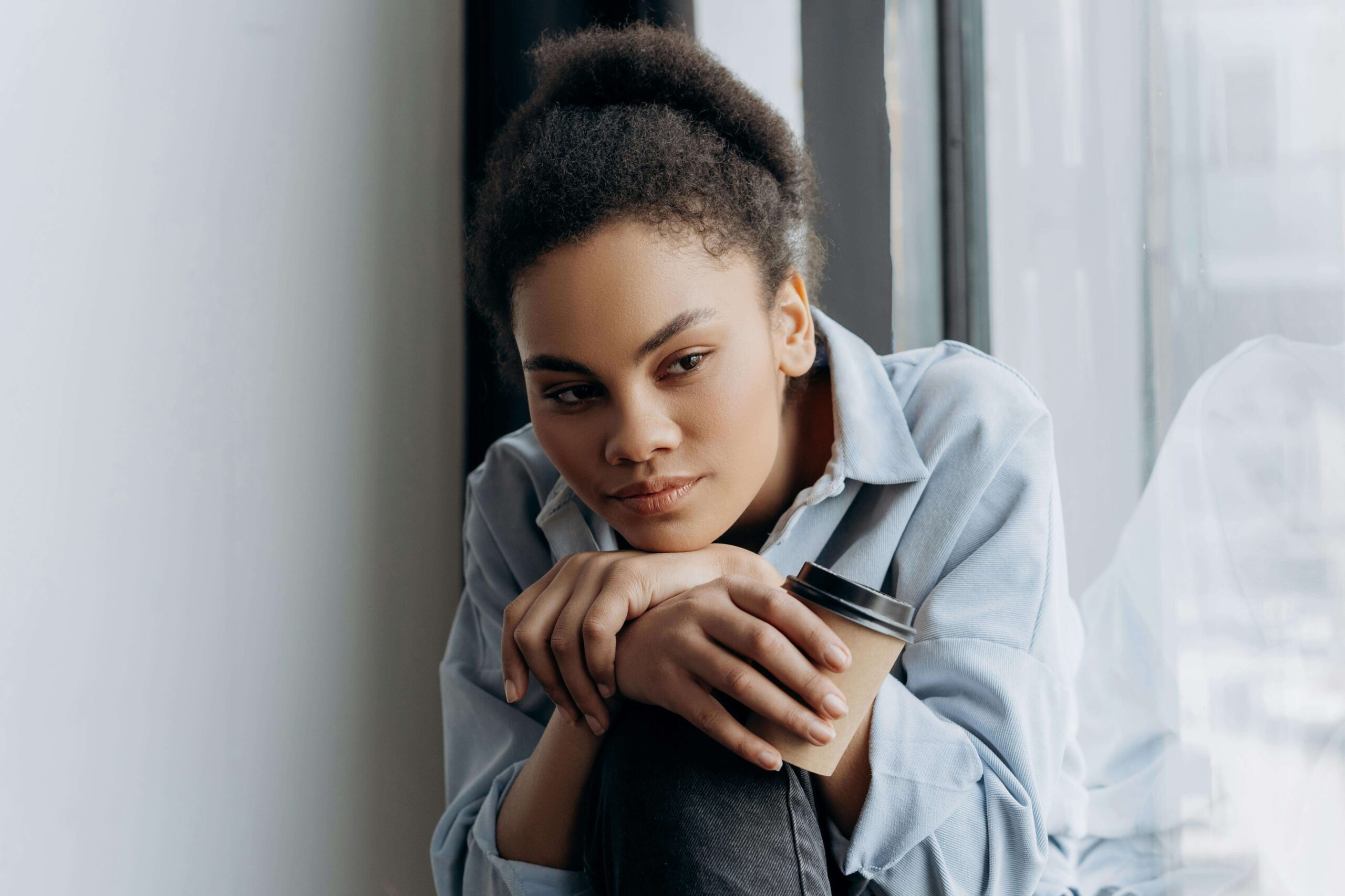 Woman reflecting thoughtfully, representing self-awareness explored in individual relationship counseling vs. couples counseling in Denver, CO.