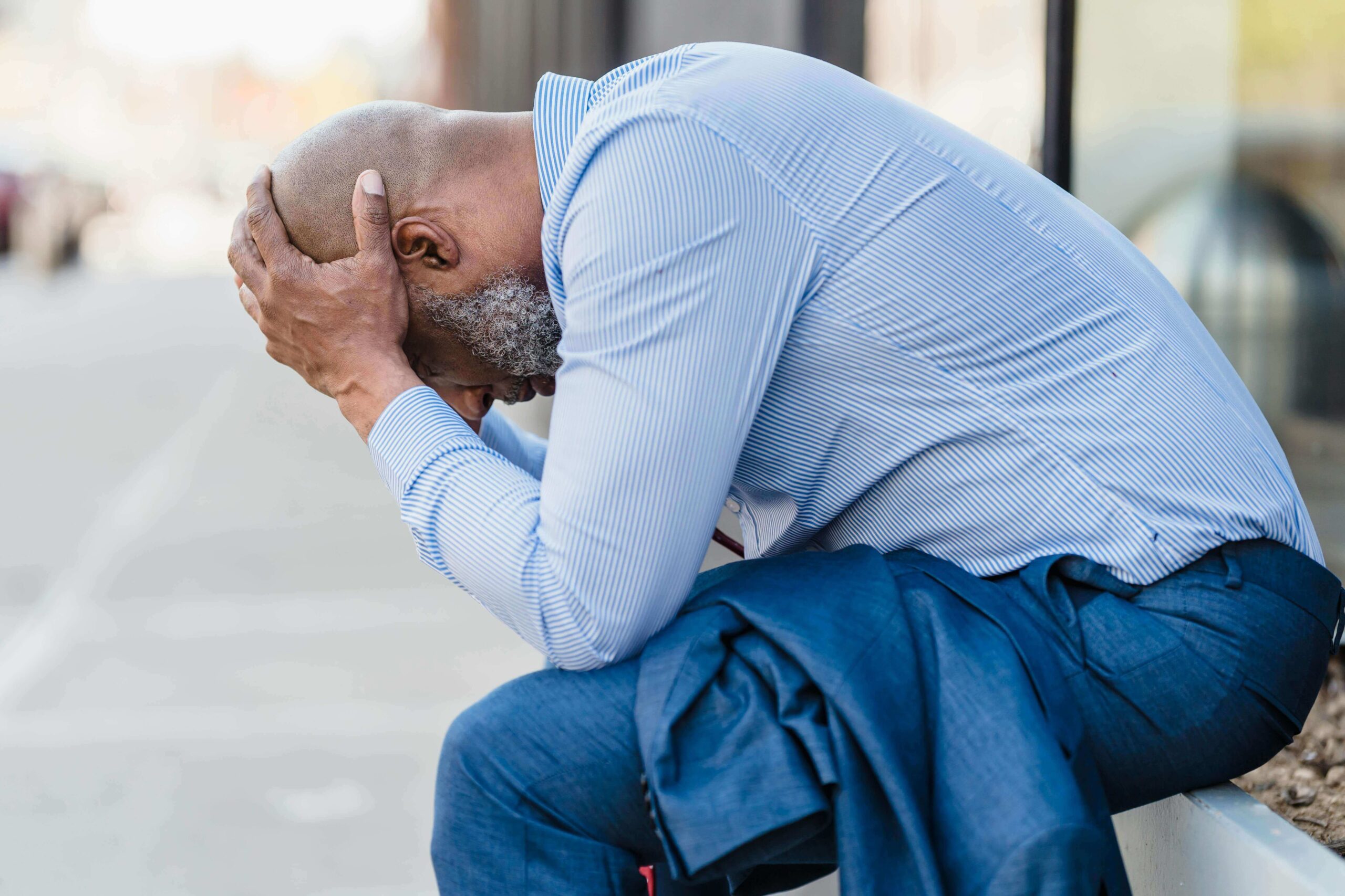 Man with his face in his hands looking stressed, representing challenges explored in men’s individual relationship counseling in Denver, CO.