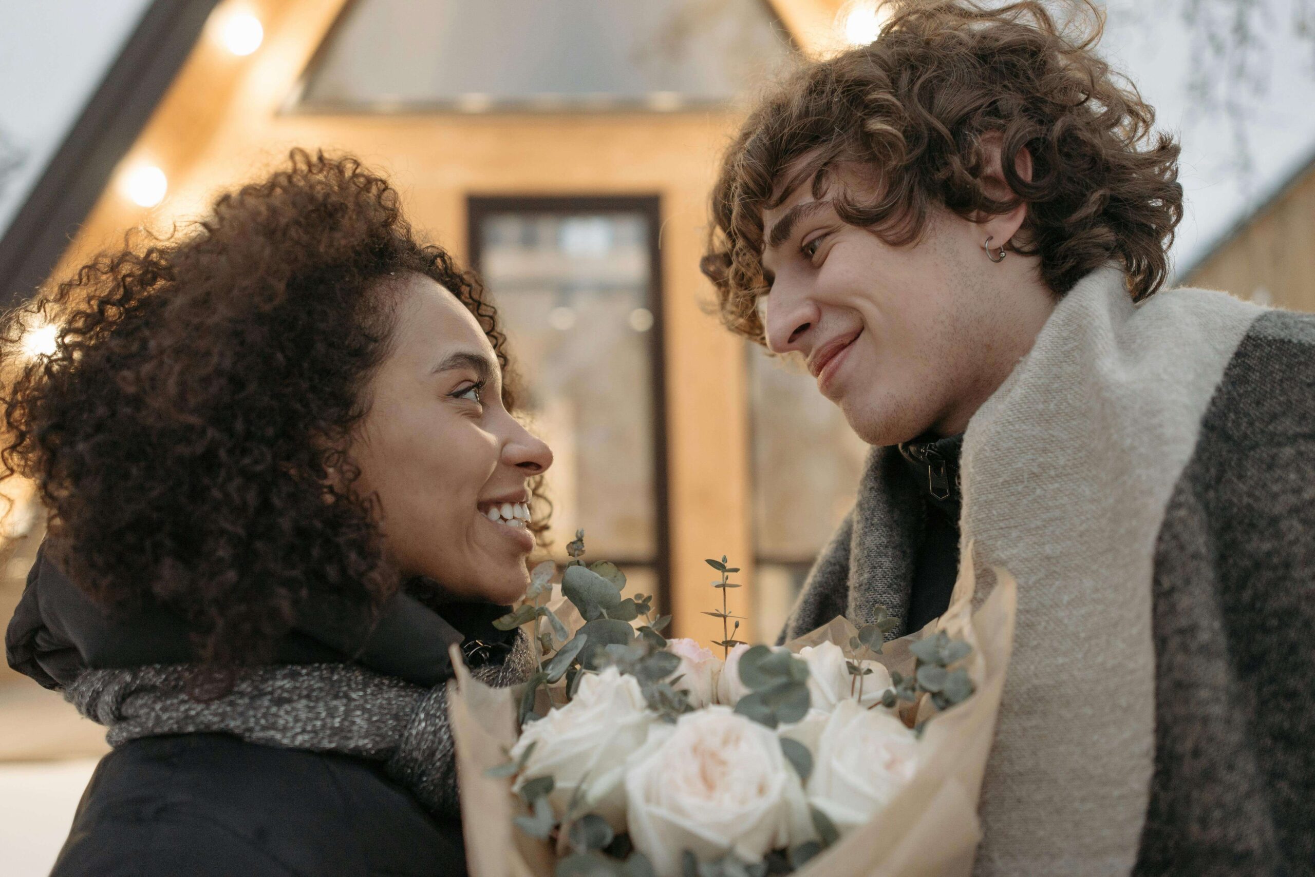 Close-up of a happy couple smiling with a bouquet of flowers, symbolizing growth and healthier relationships supported by individual relationship counseling for people pleasing in Denver, CO.