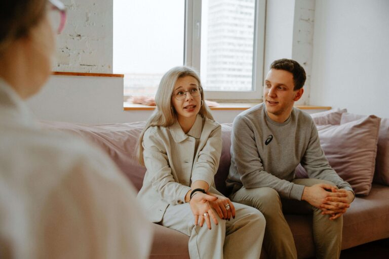 Couple sitting together in a couples counseling session, illustrating relational support discussed in individual relationship counseling vs. couples counseling in Denver, CO.