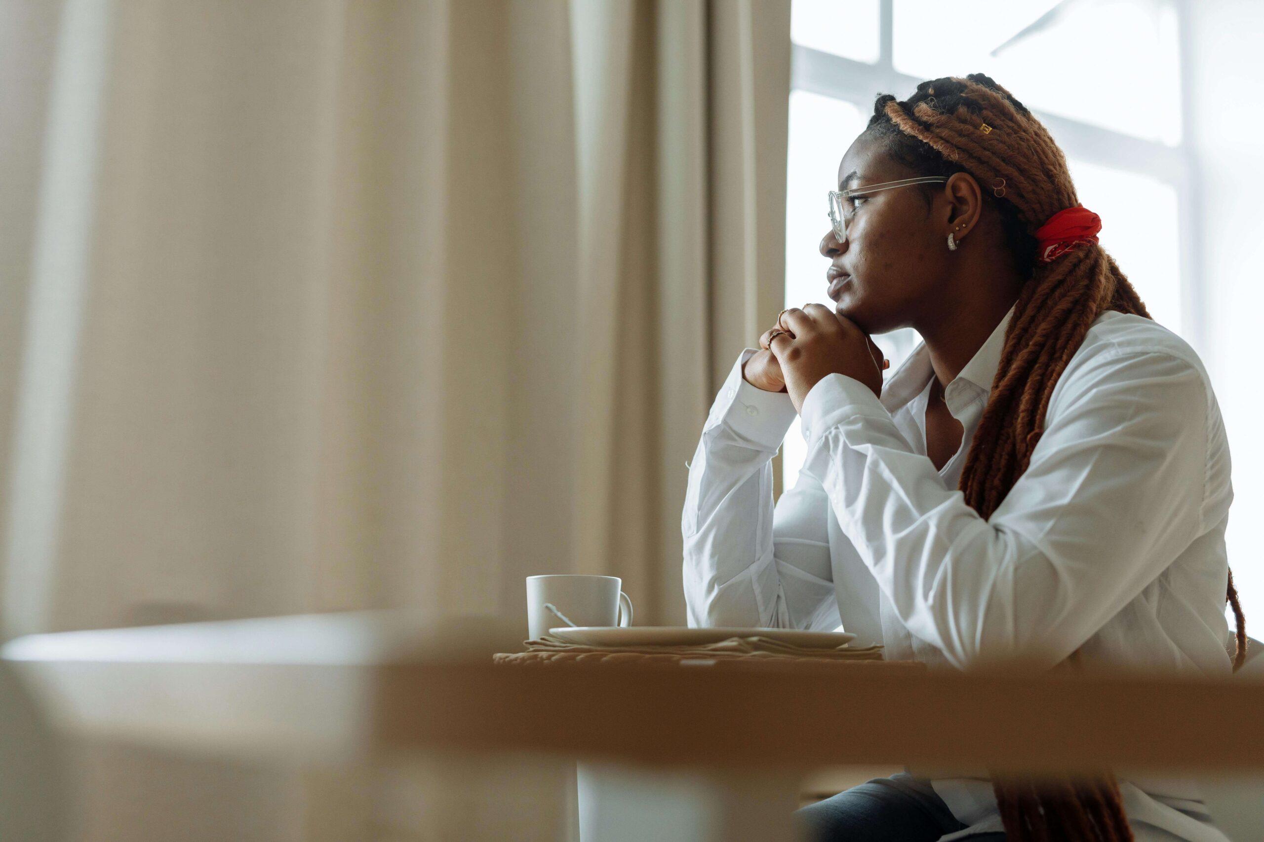 Woman looking deep in thought, illustrating self-awareness and emotional processing in individual relationship therapy for women seeking long-term relational healing in Denver, CO.