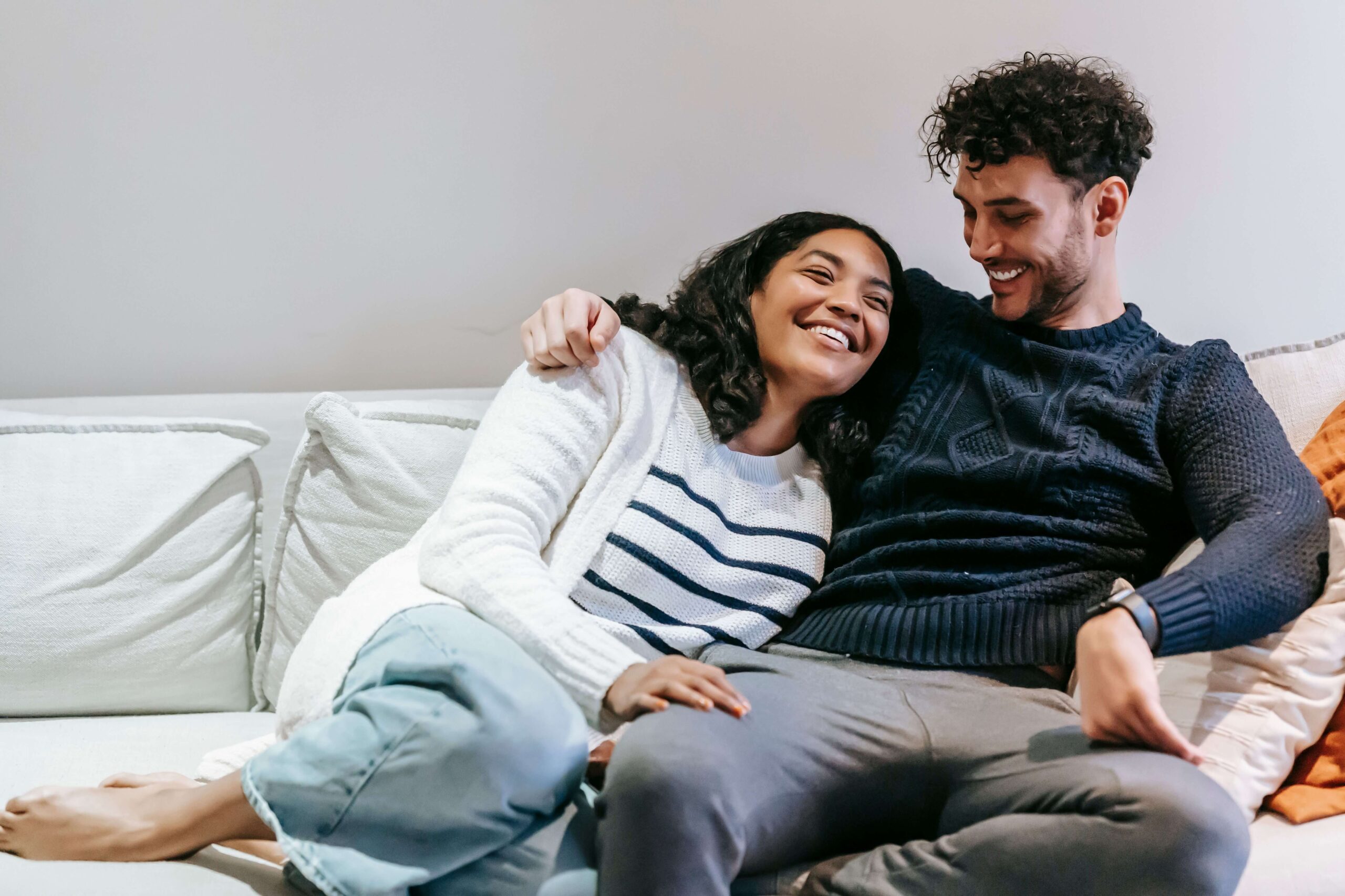 Healthy Connection - therapy for self confidence denver - individual relationship therapy for self confidence denver co - individual relationship therapist denver co - colorado Happy couple embracing on a couch and smiling, symbolizing secure relationships and lasting change supported through individual relationship therapy for self-respect in Denver, CO.